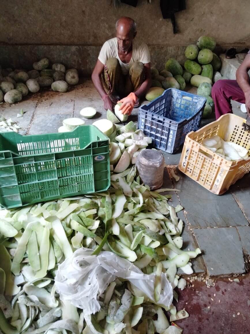 Worker peeling and preparing ash gourds in an Agra petha workshop