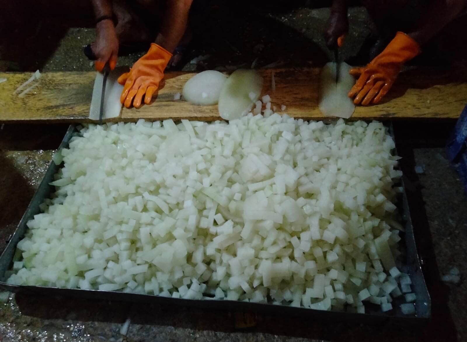 Workers cutting peeled ash gourd into small pieces